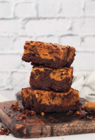 a stack of PUMPKIN brownies on a wooden board
