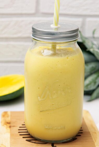 a Mango Pineapple Smoothie in a glass jar with a straw