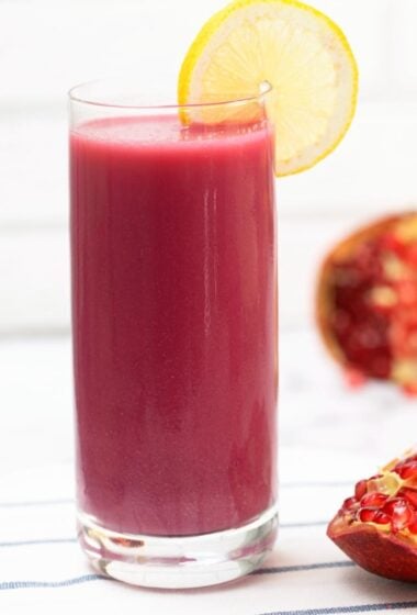 a glass of Pomegranate Juice. with a slice lemon